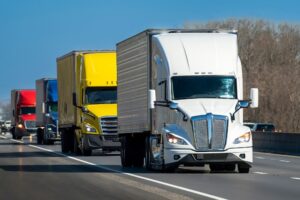 Convoy of heavy semi trucks on the highway.